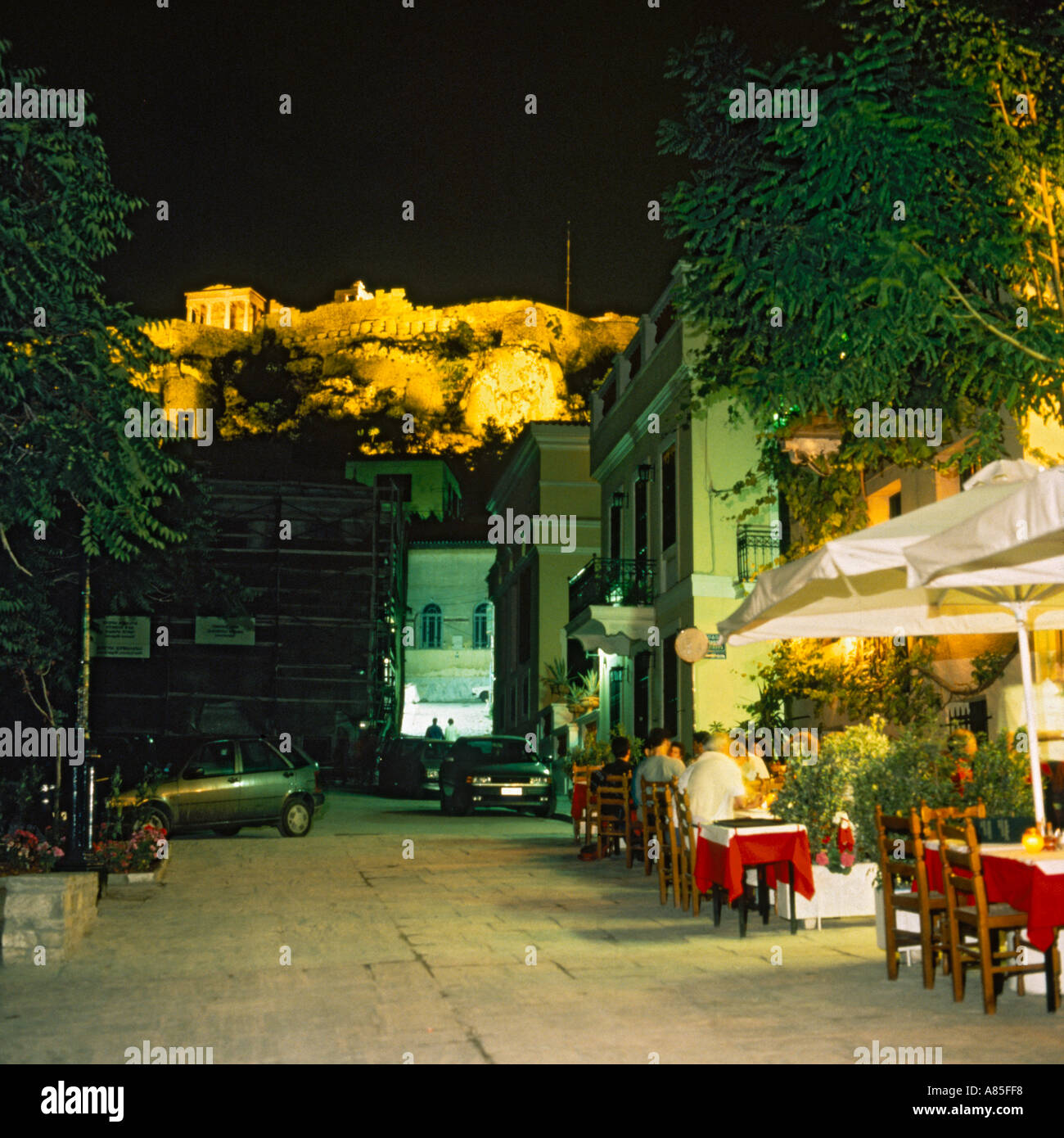 Menschen Essen in einer ruhigen Straße im Viertel The Plaka unterhalb der Akropolis zeigt das Erechtheion bei Nacht Athen Griechenland Stockfoto