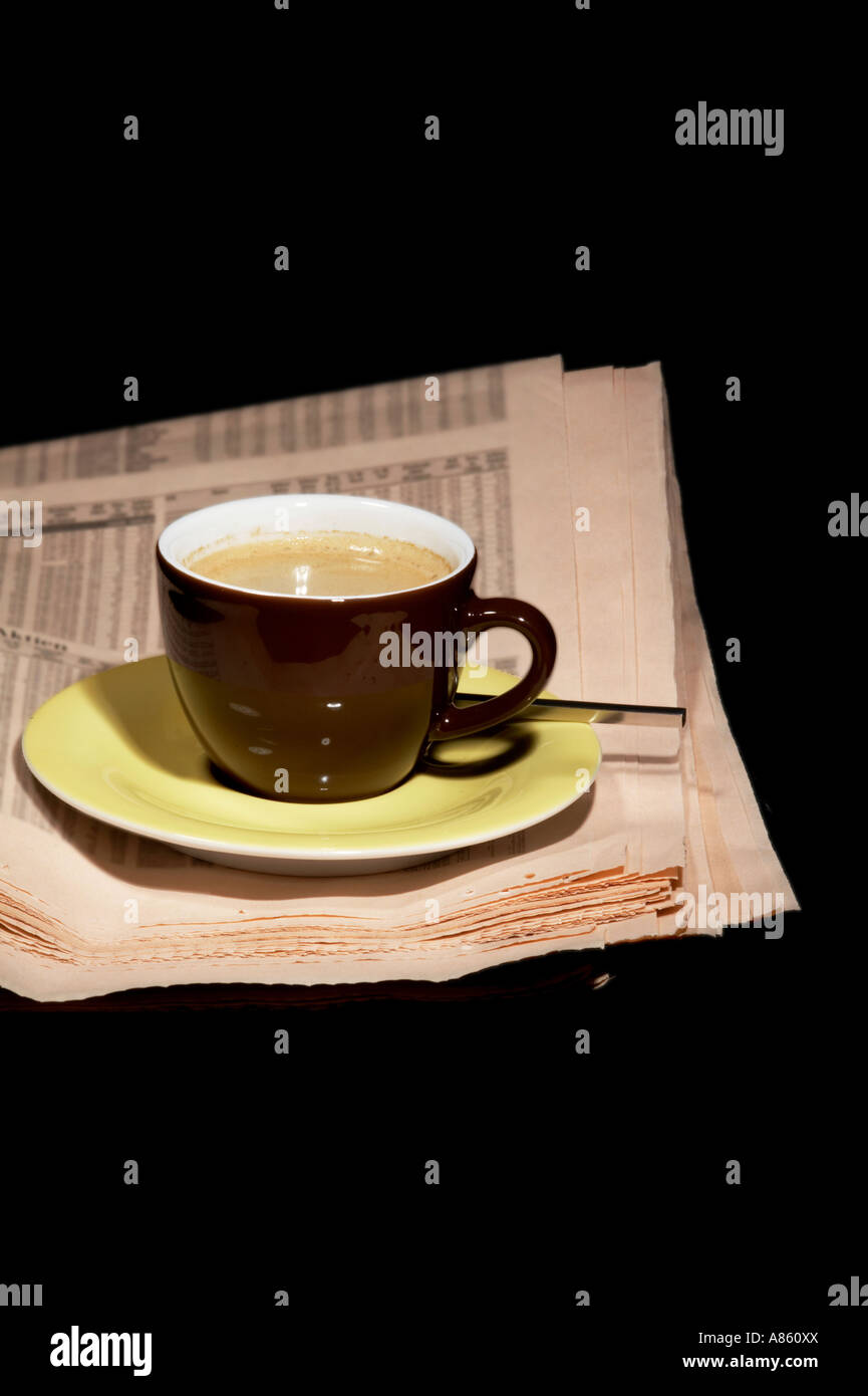 Braune Tasse Kaffee und Zeitung auf schwarzem Hintergrund isoliert Stockfoto