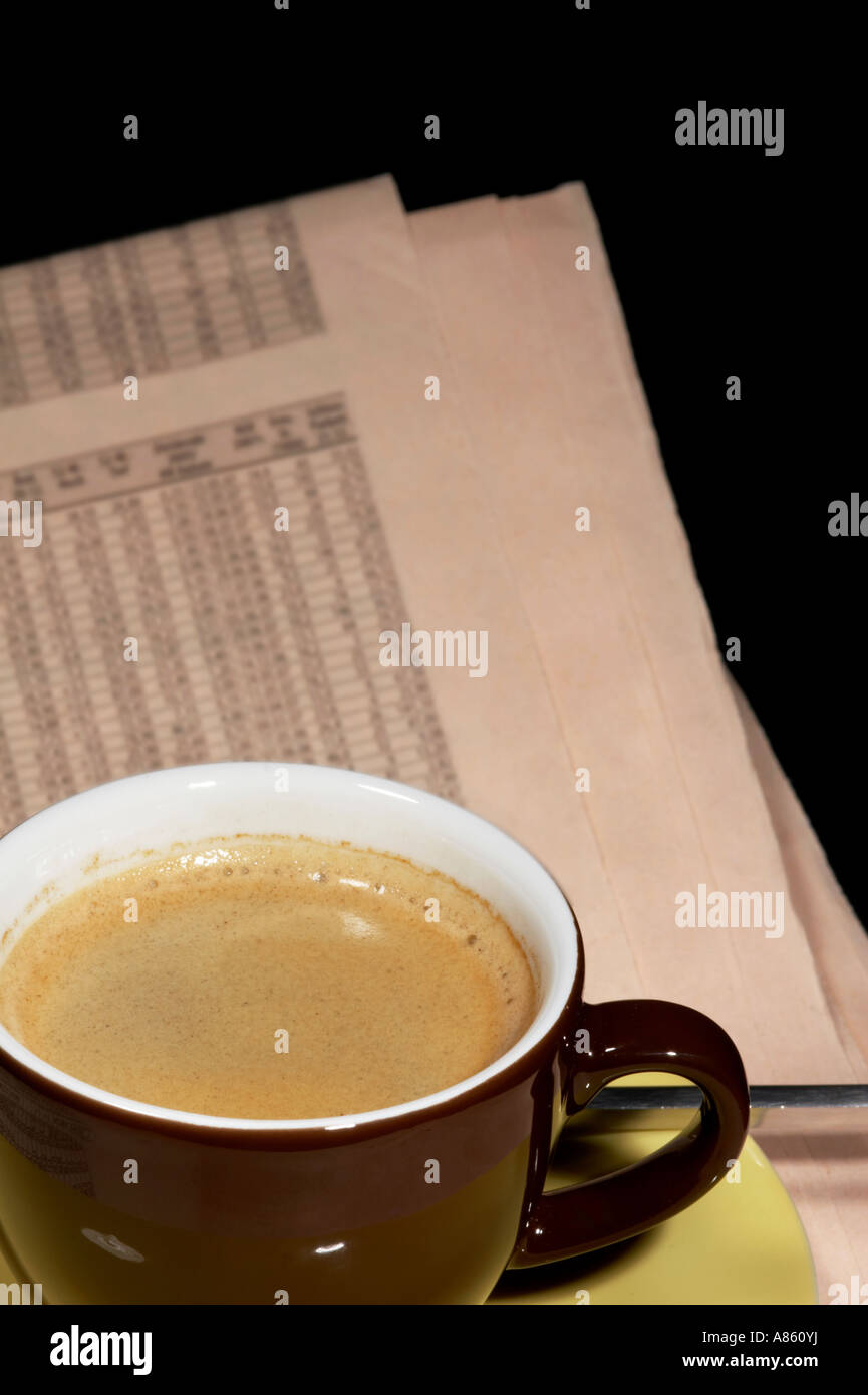 Braune Tasse Kaffee und Zeitung auf schwarzem Hintergrund isoliert Stockfoto