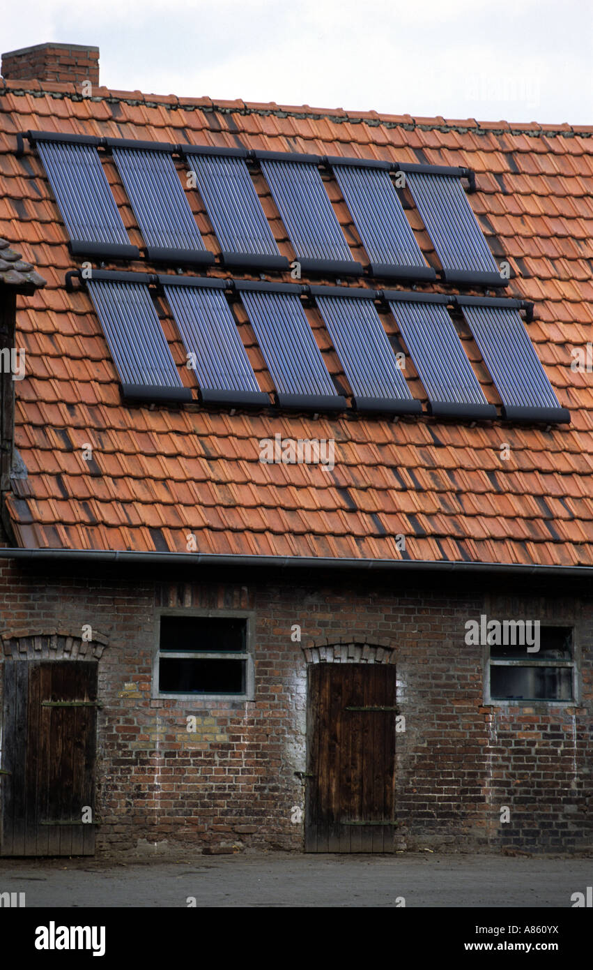 Vakuum-Röhren zur Warmwasseraufbereitung durch Solarenergie auf landwirtschaftlichen Gebäuden in Wagenfeld, Niedersachsen, Deutschland. Stockfoto