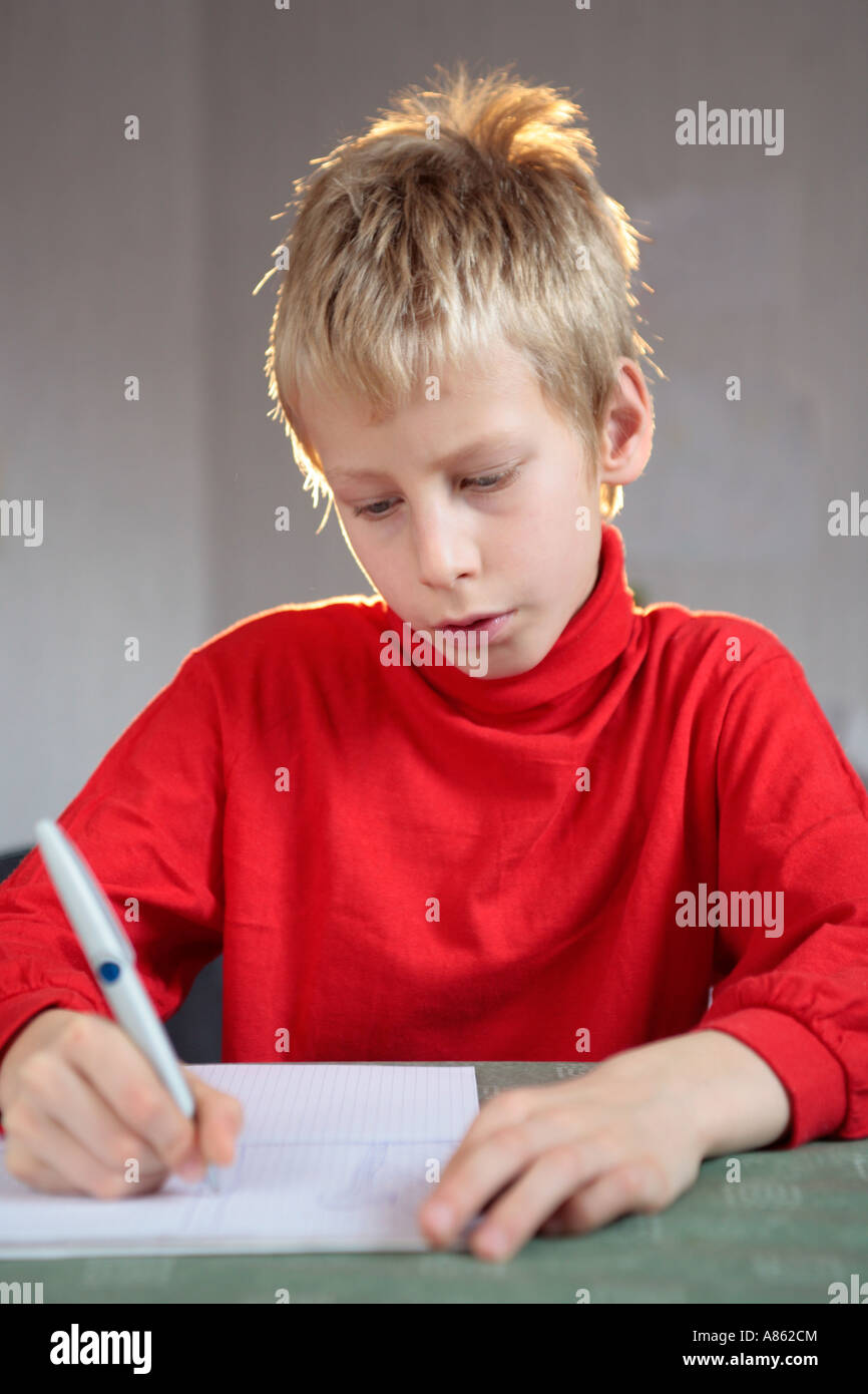 Porträt eines fair haired Jungen konzentriert sich auf sein schreiben Stockfoto