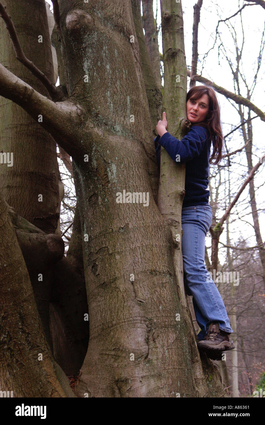 Junge weibliche umarmt einen Baum Stockfoto