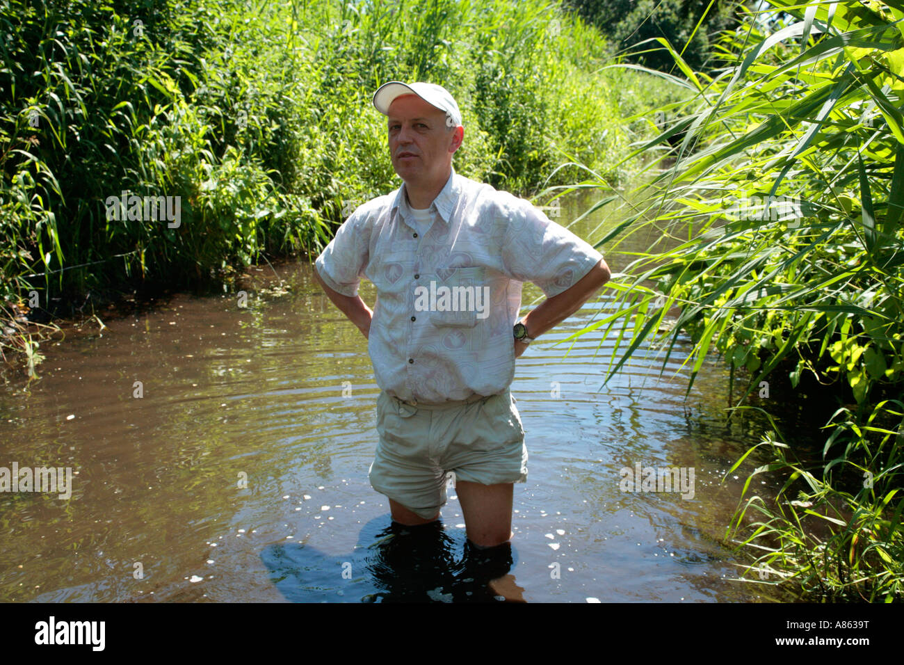 Mann mit aufgedreht Hose in einem schmutzigen Fluss stehend Stockfotografie  - Alamy