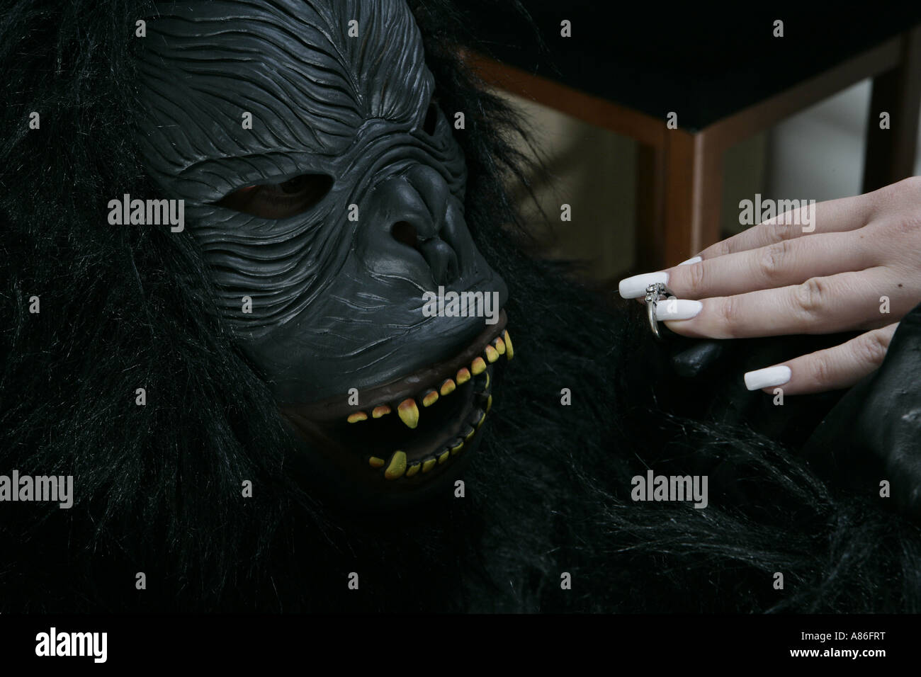 Ein Mann in eine Gorillamaske schlägt vor, eine Frau Stockfoto