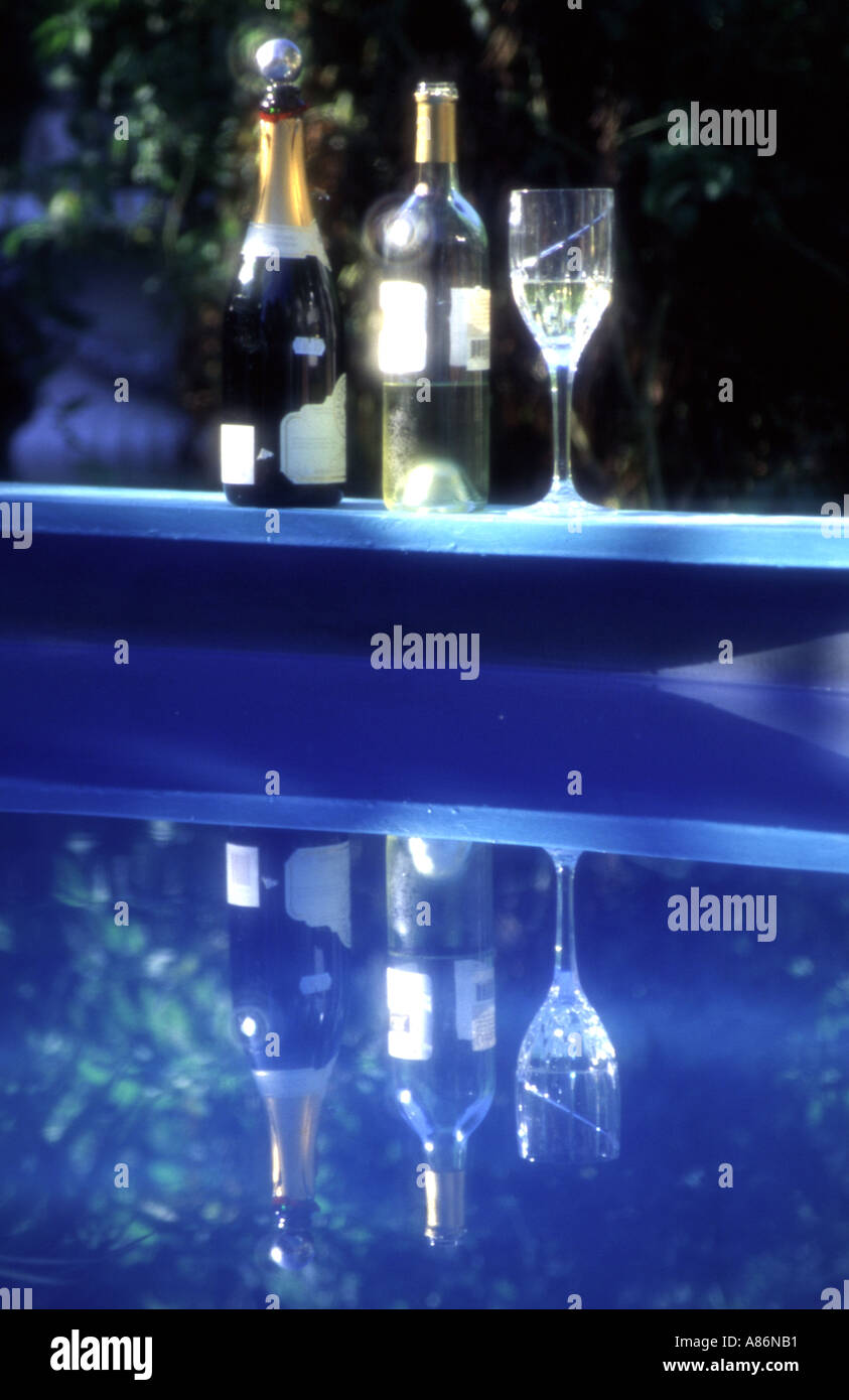 Pool Party-Sekt und Wein-Flaschen und Glas am Pool Stockfoto