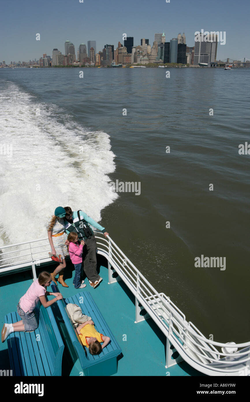 Familie von fünf auf einem Boot mit Gebäude der Stadt im Hintergrund Stockfoto