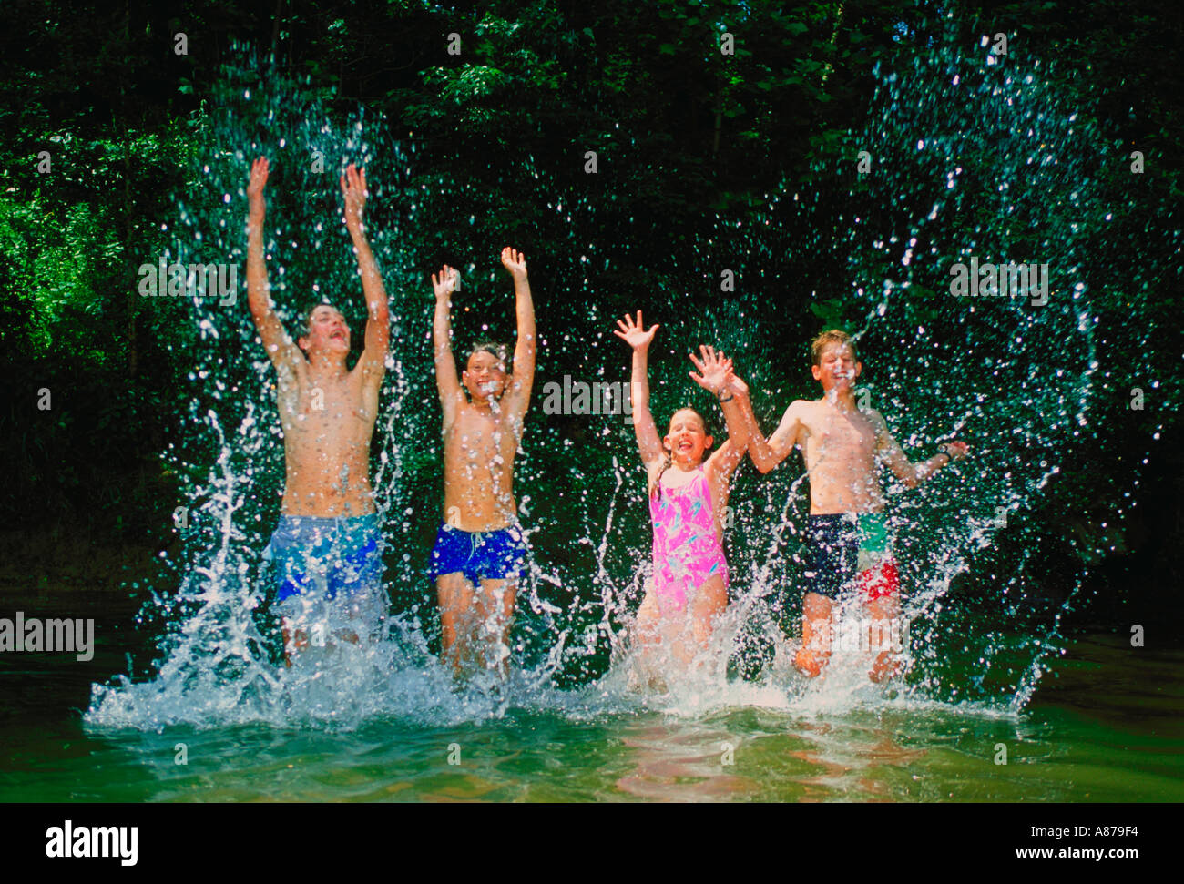 Eine Gruppe von vier Jugendlichen zum planschen und spielen in einem Fluss Stockfoto