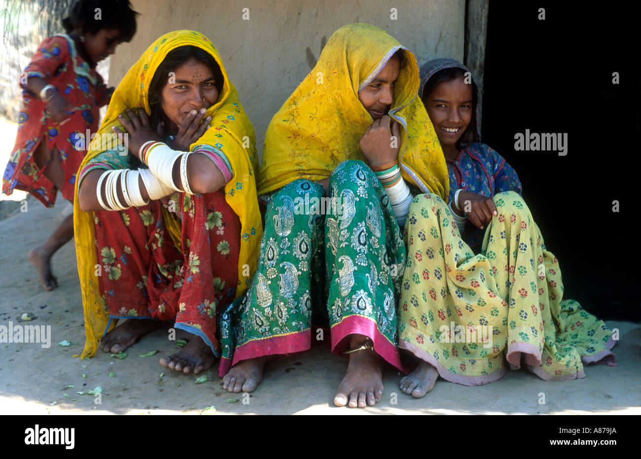Porträt von drei Schwestern in farbenfrohem traditionellen Kleid in einem armen ländlichen Dorf in Thar Parkar, Pakistan Stockfoto