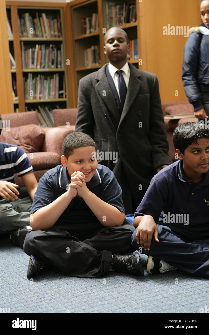 Jungs (11-13) sitzt in der Bibliothek, wegschauen Stockfoto