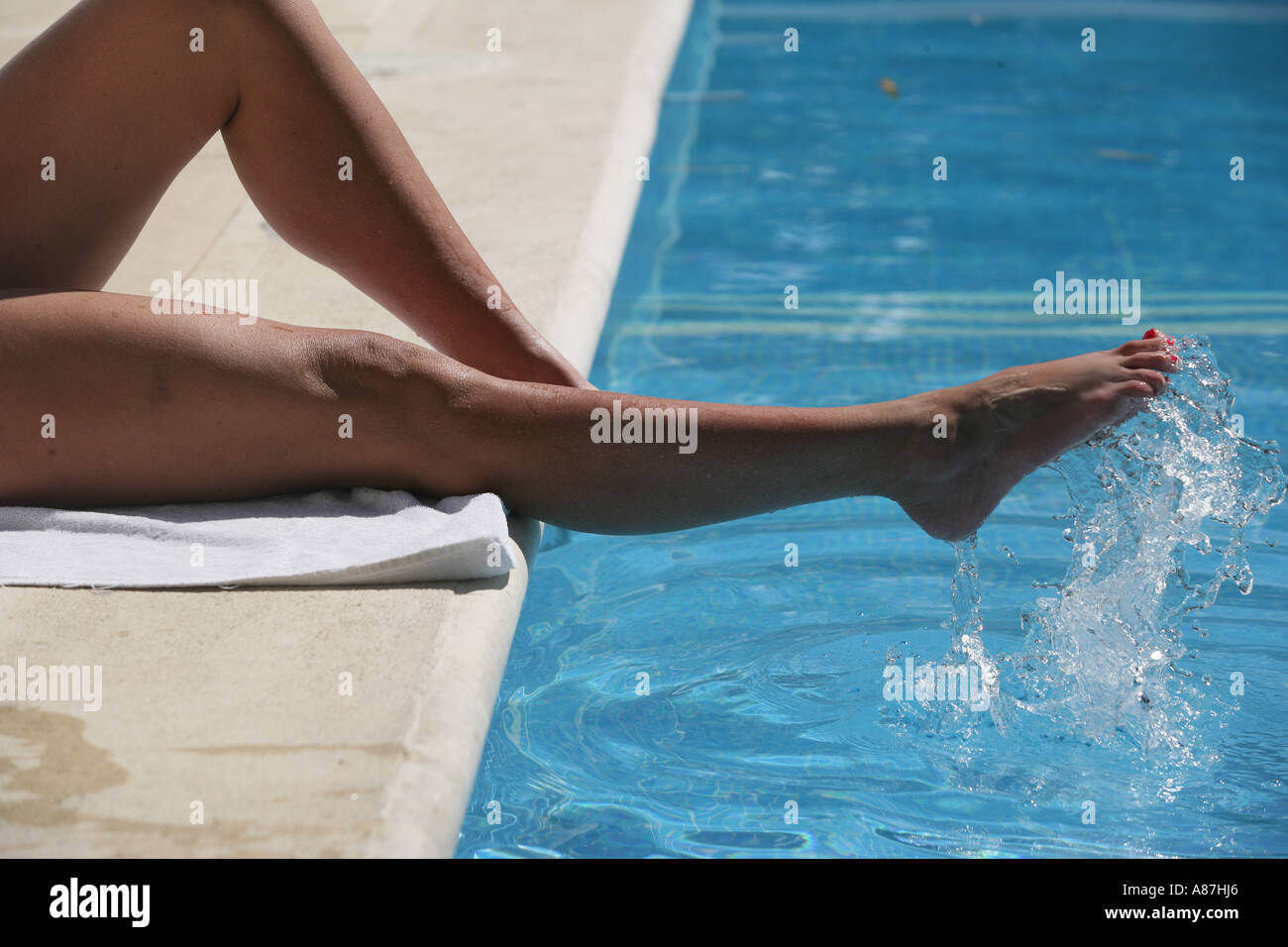 Womans Beine im Pool plantschen Füße im Pool Urlaub Konzept Entspannung Stockfoto