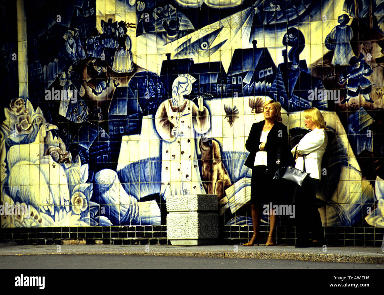 Zwei Frauen stehen auf Bürgersteig vor blau-weiße Keramik gefliest Szene, entlang der Straße in Sankt Petersburg, Russland Stockfoto