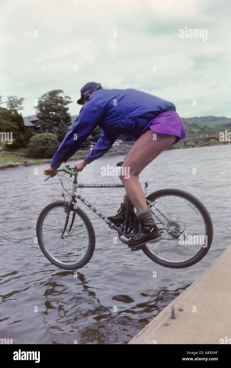 Ungestüme Biker versucht, Radfahren auf Wasser - ein cartier-bresson "entscheidende Moment' Stockfoto