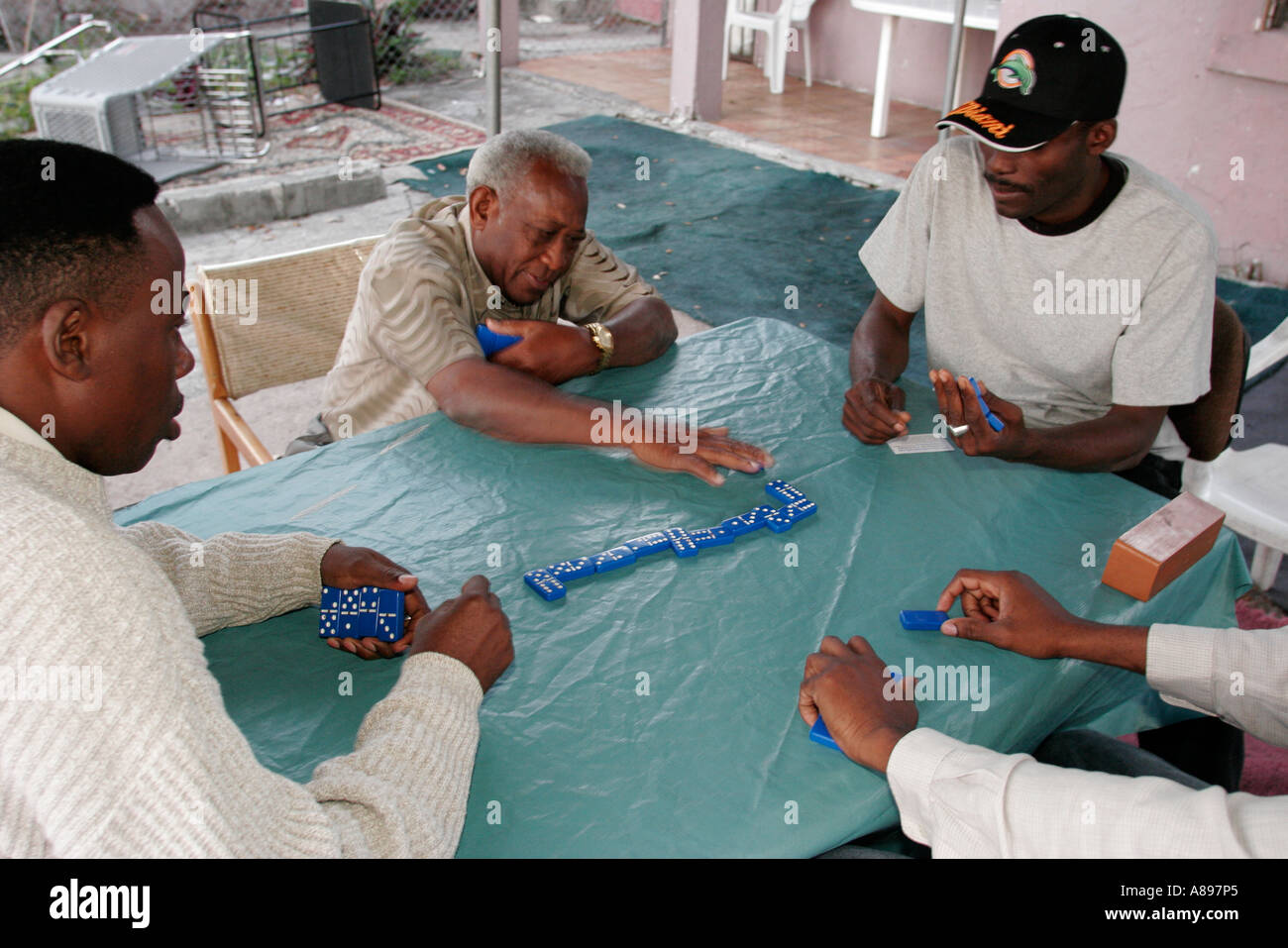 Miami Florida, Little Haiti, Schwarze Männer spielen Dominos, Tisch, Haus, Haus Häuser Häuser Wohnsitz Nachbarn, Familie Familien Eltern Eltern Kind Kinder Stockfoto