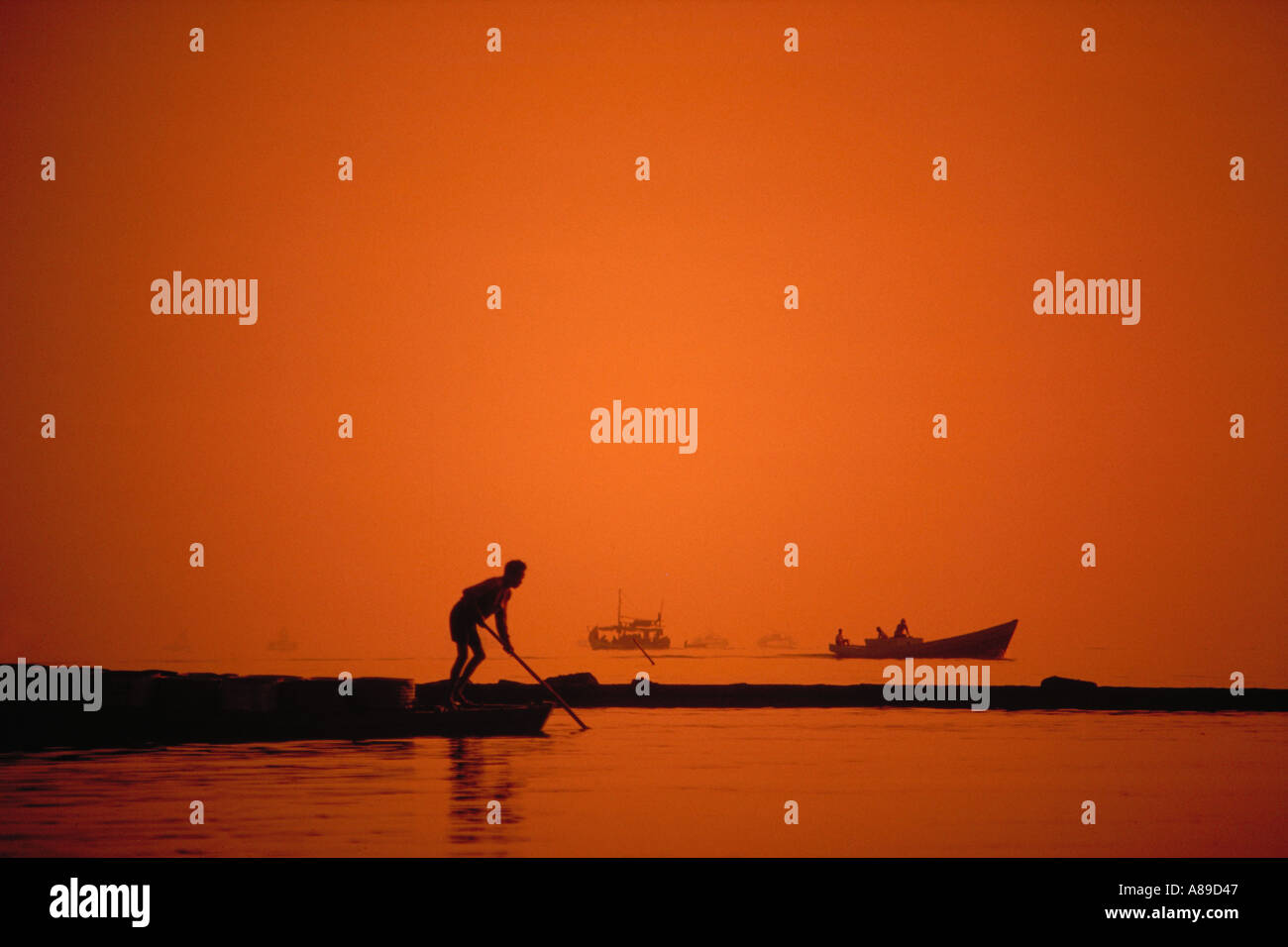 Fischer gegen einen orangefarbenen Himmel in Jakarta Hafen Java Indonesien Stockfoto