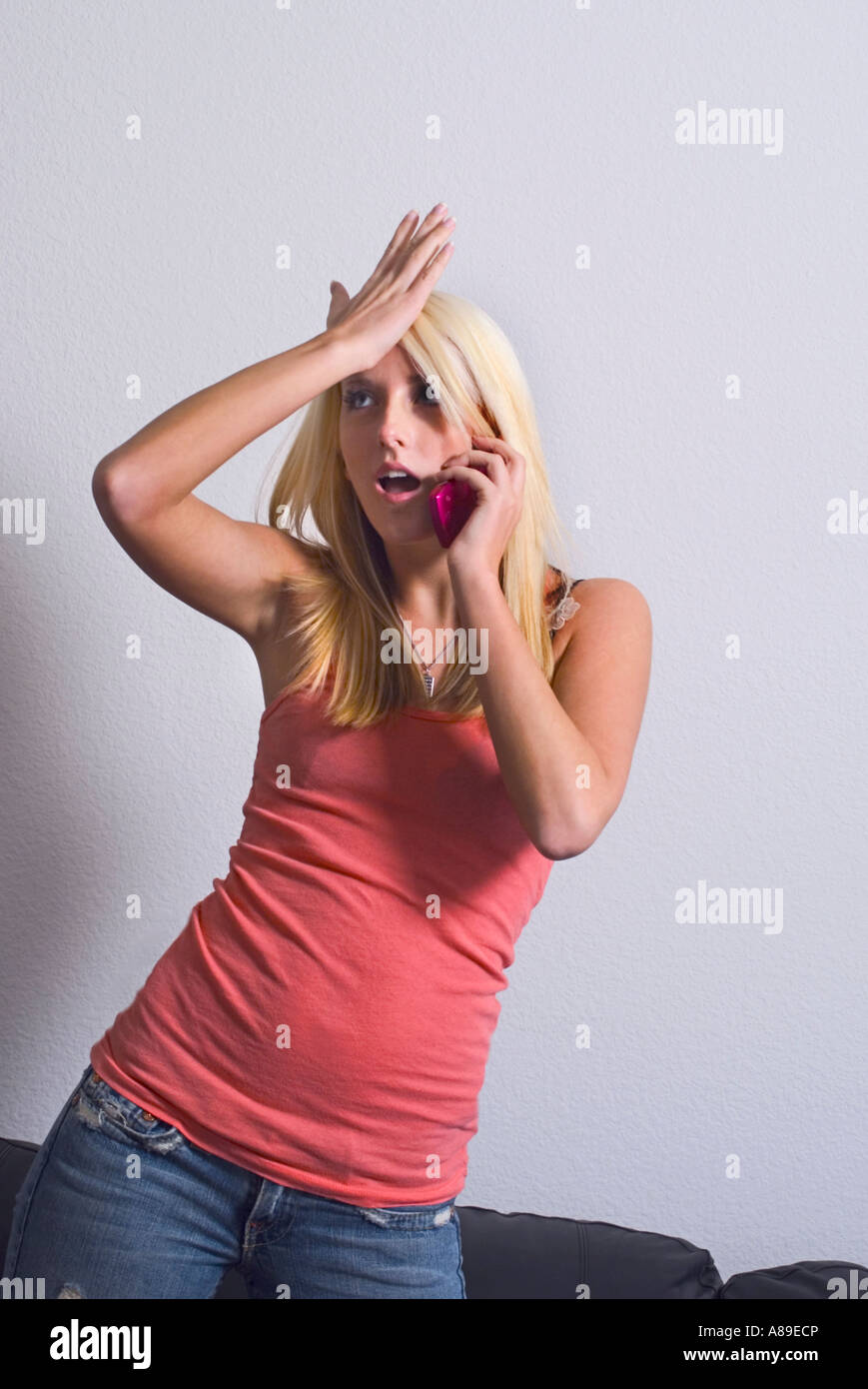 Eine Frau trifft ihre Stirn während des Gesprächs am Telefon anzeigend duh ich daran gedacht haben sollte Stockfoto