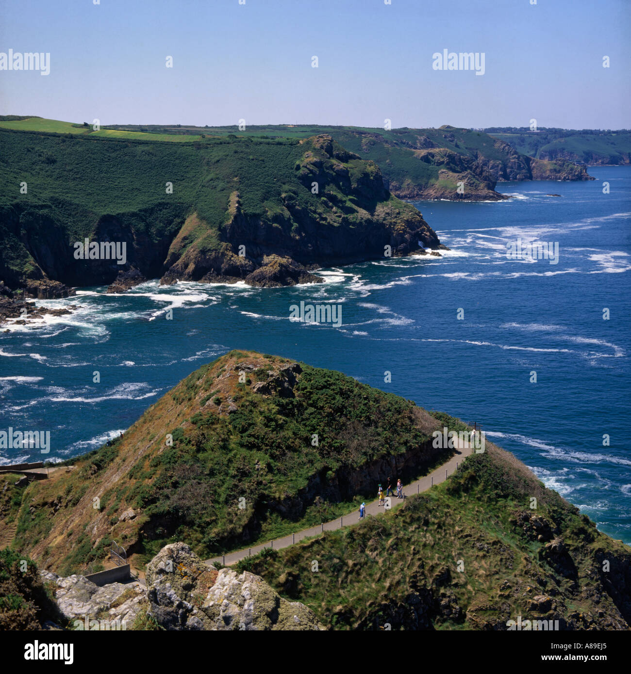 Blick nach Westen auf des Teufels Loch Küste mit Menschen am Weg unten herum kreisförmige Knoll St Mary in Jersey Channel Islands Stockfoto