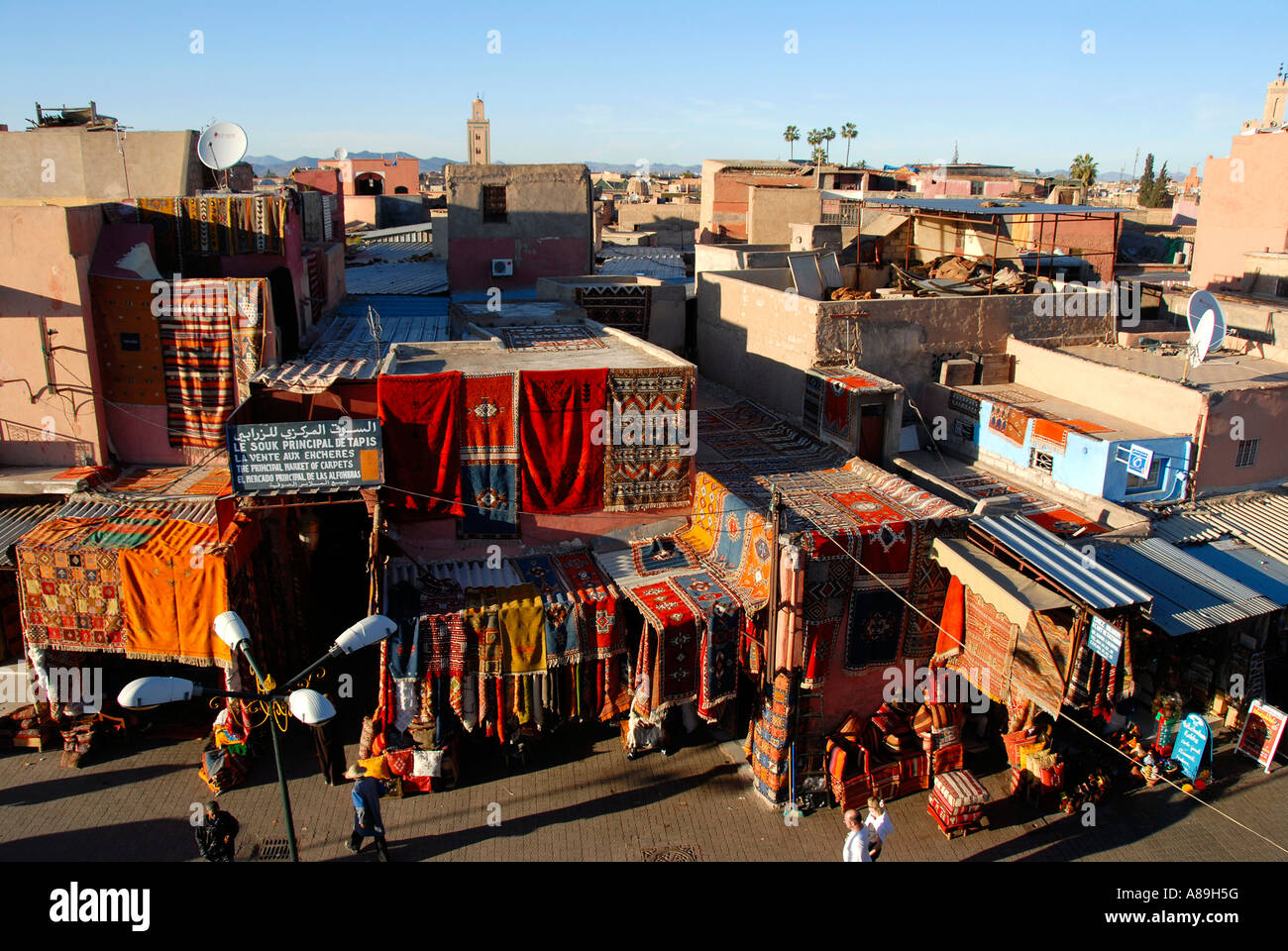 Blick über die Dächer der Stadt Teppiche hängen an Fassaden Place Rahba Qedima Medina Marrakesch Marokko Stockfoto