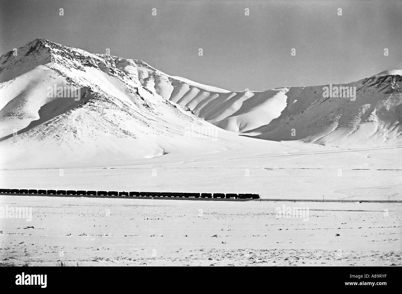 IRAN ARAK Zug überqueren einer verschneiten Hochebene in den Bergen von Iran schwarz und weiße dramatische Landschaft drucken Stockfoto