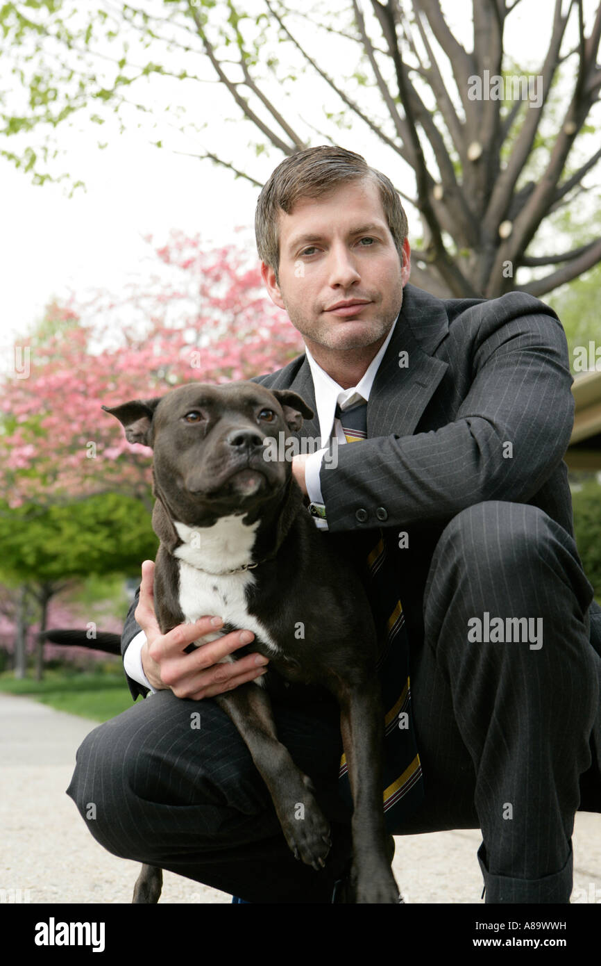 Business-Mann hält einen Hund Stockfoto