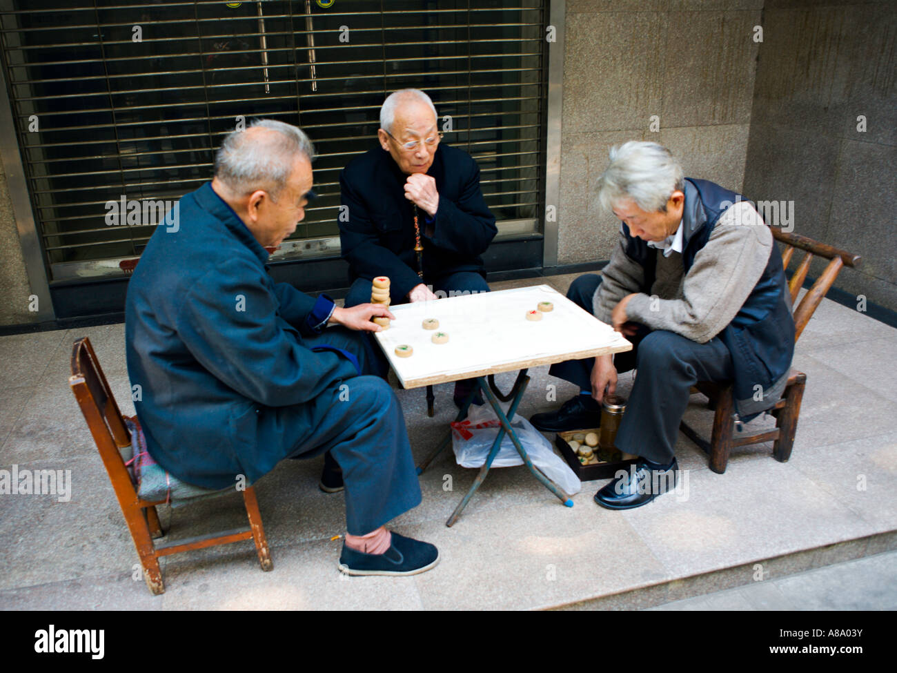 CHINA WUHAN ältere chinesische Männer spielen Xiangqi oder chinesisches Schach ein traditionelles chinesisches Brettspiel von Geschick und Glück auf der sidew Stockfoto