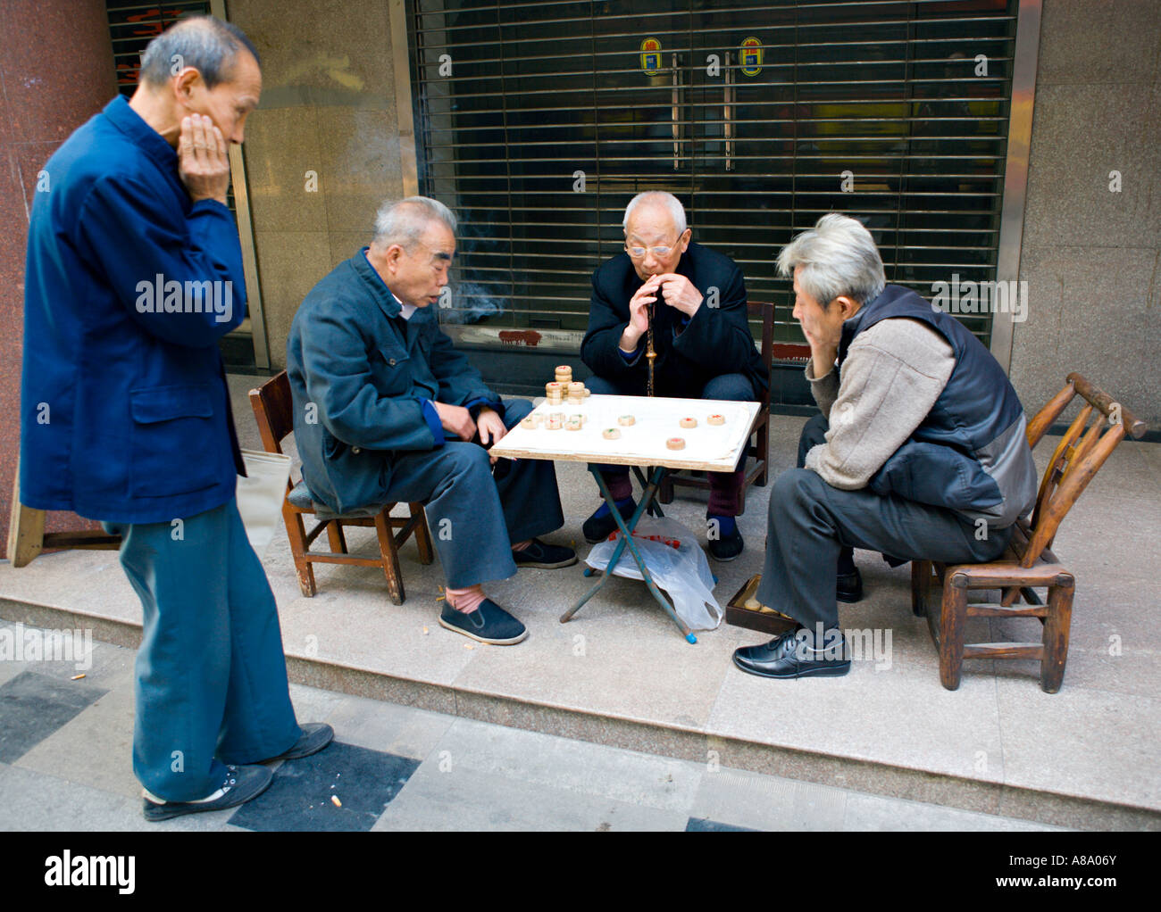 CHINA SHANGHAI ältere chinesische Männer spielen Xiangqi oder chinesisches Schach ein traditionelles chinesisches Brettspiel von Geschick und Glück auf einen stre Stockfoto