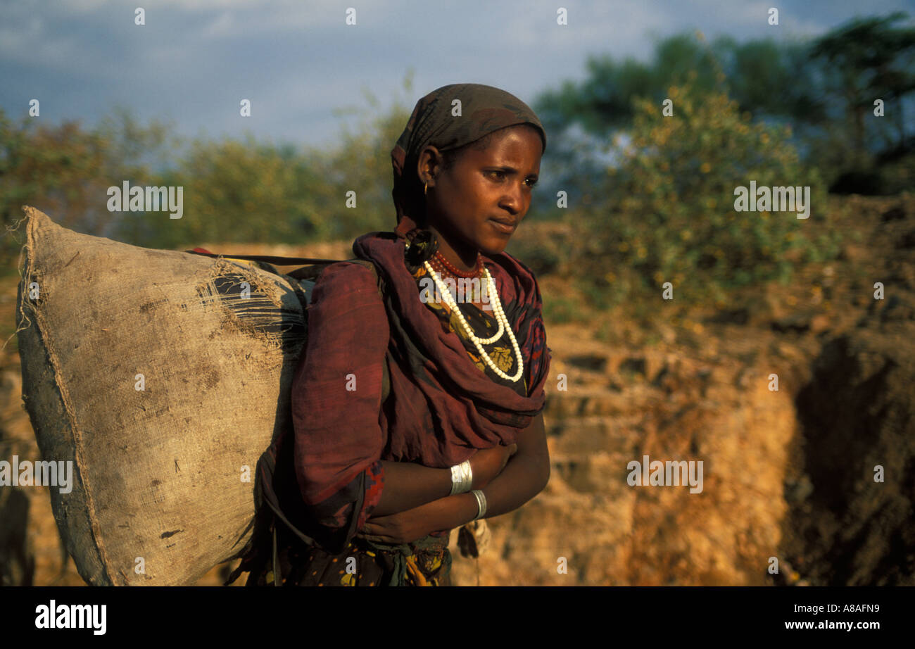 Borena Mädchen tragen die Last auf dem Rücken, außerhalb Yabello, Äthiopien Stockfoto