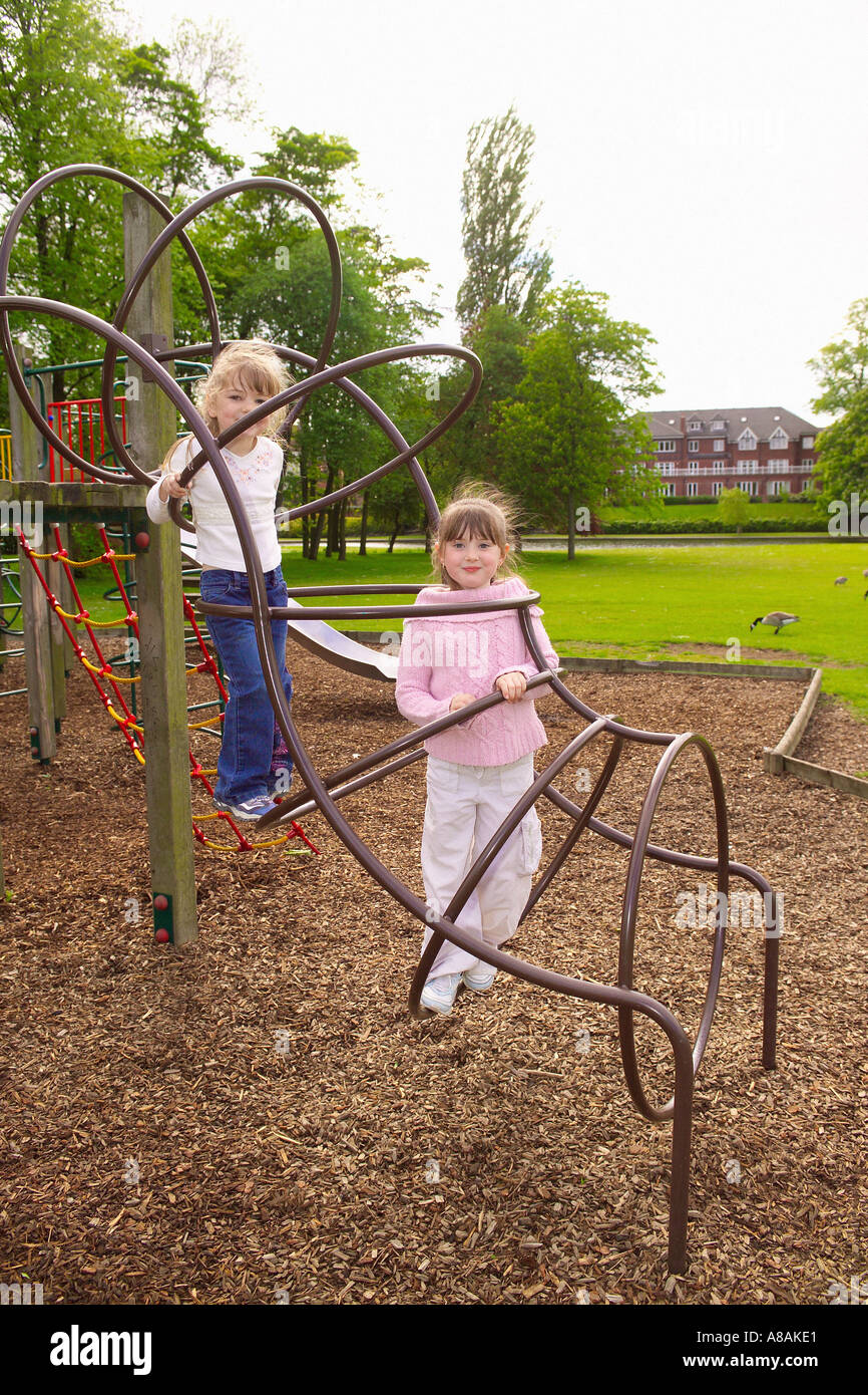 Zwei junge Mädchen, die auf einem Klettergerüst spielen und Rinde auf dem Boden abplatzen, um Sicherheit im Rowntree Park zu gewährleisten. York . UK Stockfoto