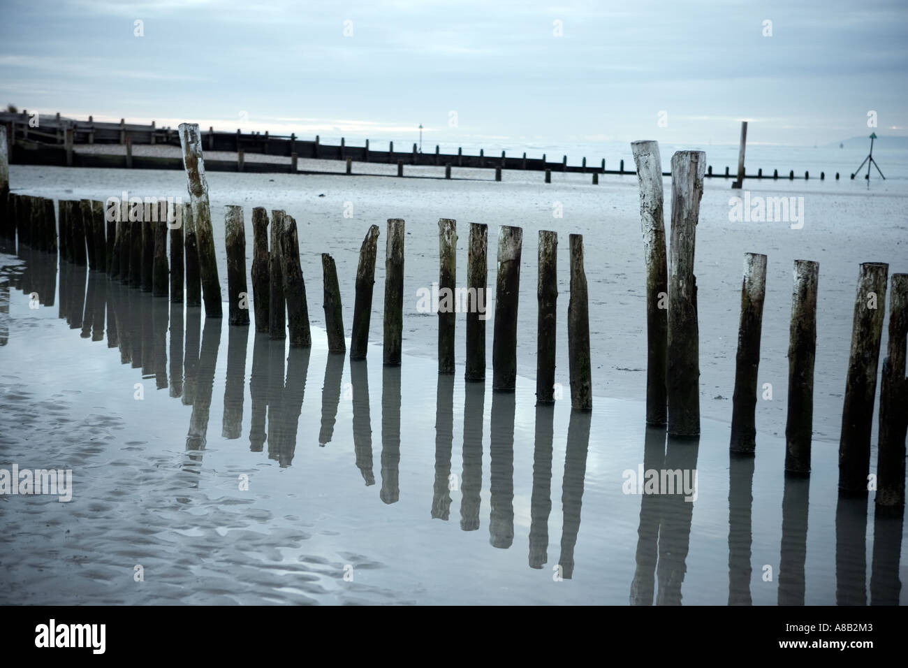 Seascape Schuss der hölzerne Ständer spiegelt sich im Wasser bei Ebbe an der britischen Küste Stockfoto