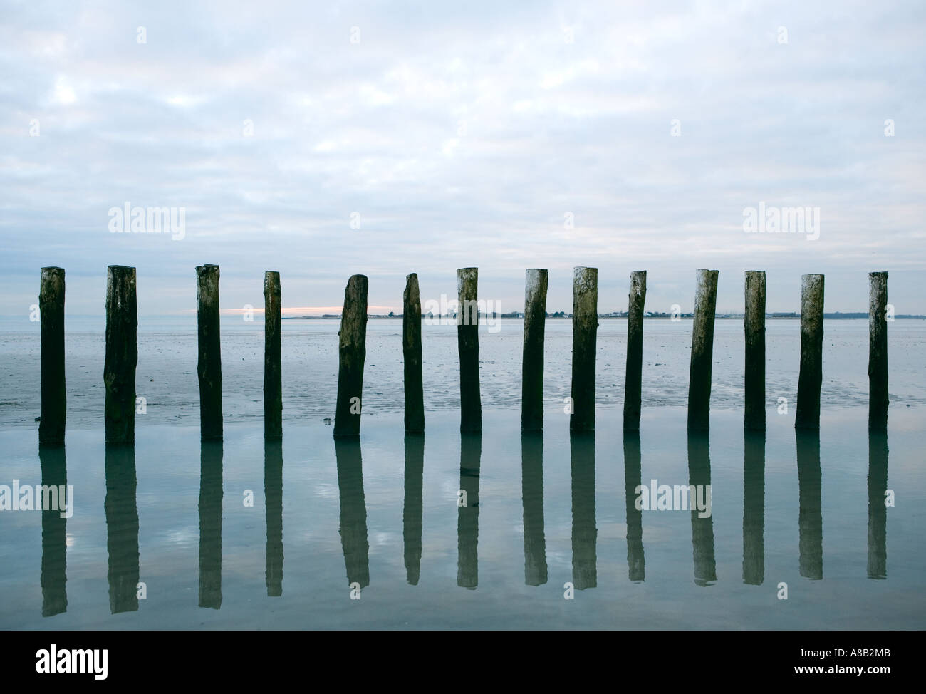 Seascape Schuss der hölzerne Ständer spiegelt sich im Wasser bei Ebbe an der britischen Küste Stockfoto