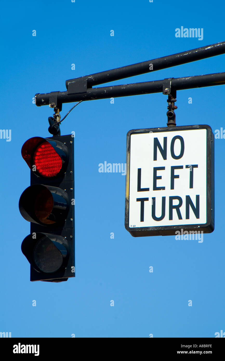 Ampel mit Rotlicht und keine links drehen Schild hängen von der Pole Position gegen blauen Himmel Stockfoto