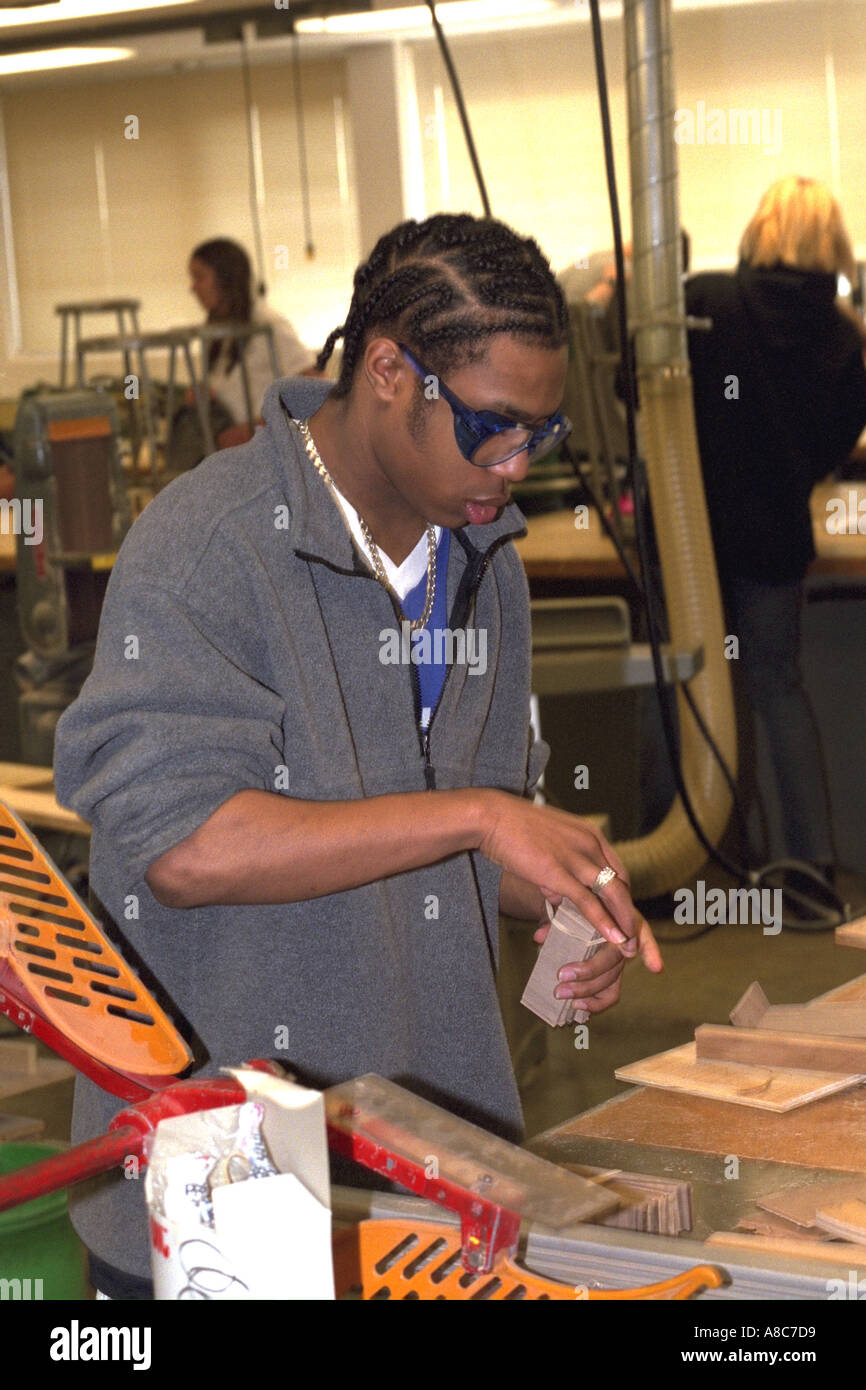 Schwarzen Studenten mit 14 Jahren Anwendung Kleber auf Schul-Shop-Projekt. Golden Valley, Minnesota USA Stockfoto