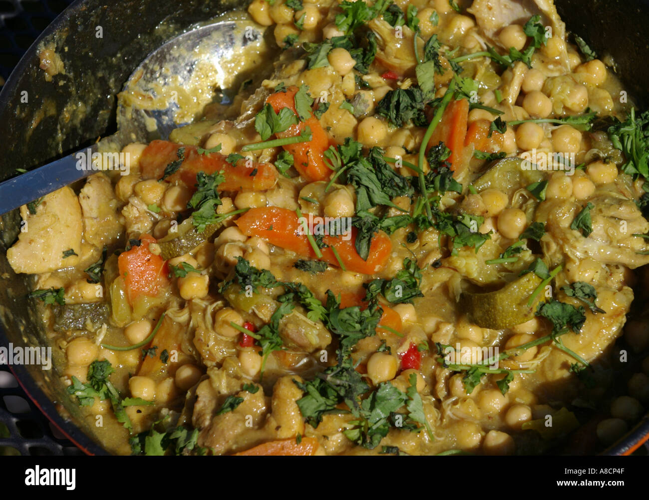 ein Morrocan Tagine mit Küken Erbsen Huhn und Koriander in einer gusseisernen Pfanne Stockfoto