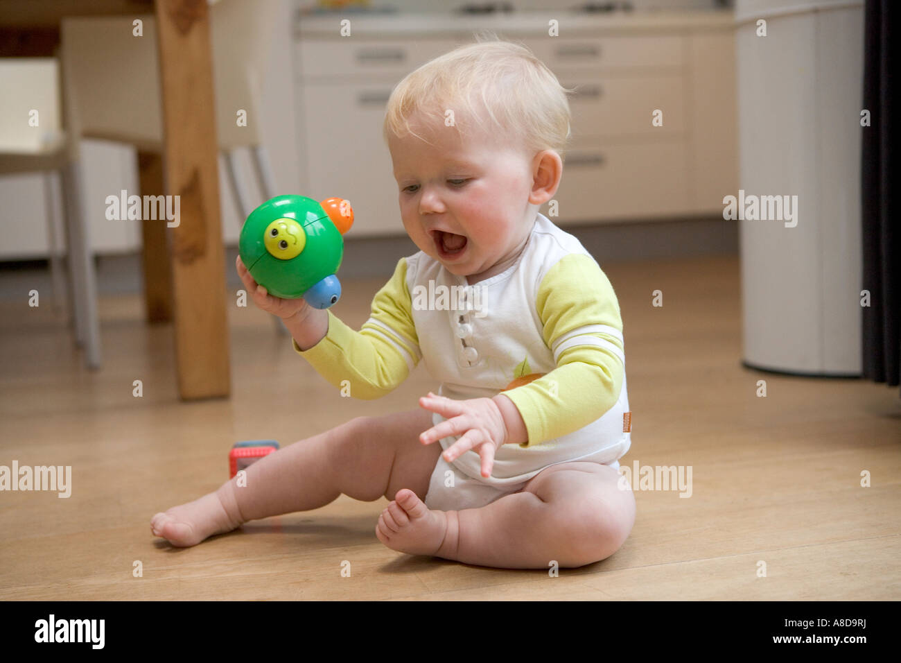 Kind auf dem Boden mit einem Spielzeug spielen Stockfoto