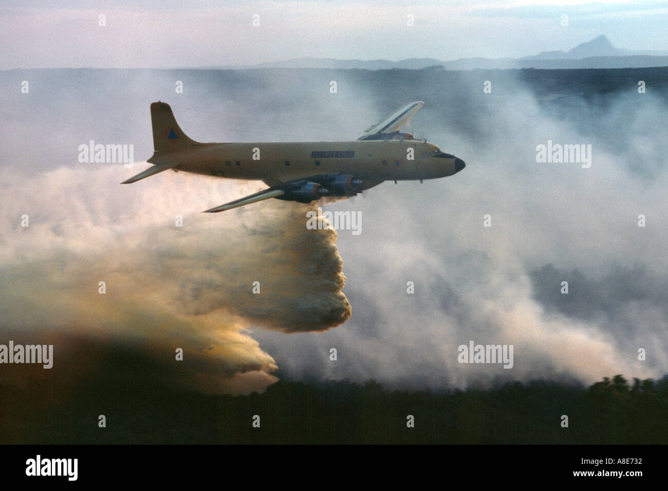 Luftaufnahme von eine Douglas DC-6B Löschwasser bomber Flugzeug fallen Feuerhemmende über ein wildfire, Feuer Rauch, Provence, Frankreich, Europa, Stockfoto