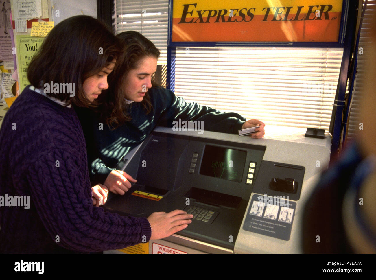 Schwestern Alter 16 und 18 mit Geldautomat. St Paul Minnesota USA Stockfoto