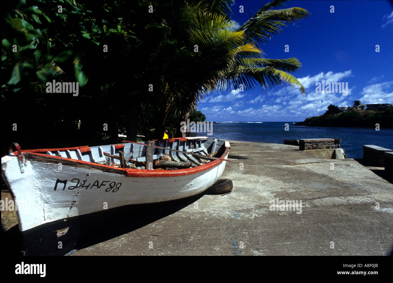 Eine weiße und rote Fischerboot liegt auf einem Steg in der Küstenstadt von Souillac, Mauritius. Stockfoto