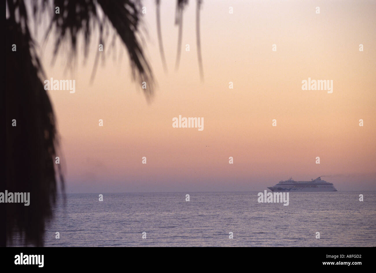 Kreuzfahrtschiff in der Abenddämmerung vom Ufer aus gesehen Stockfoto