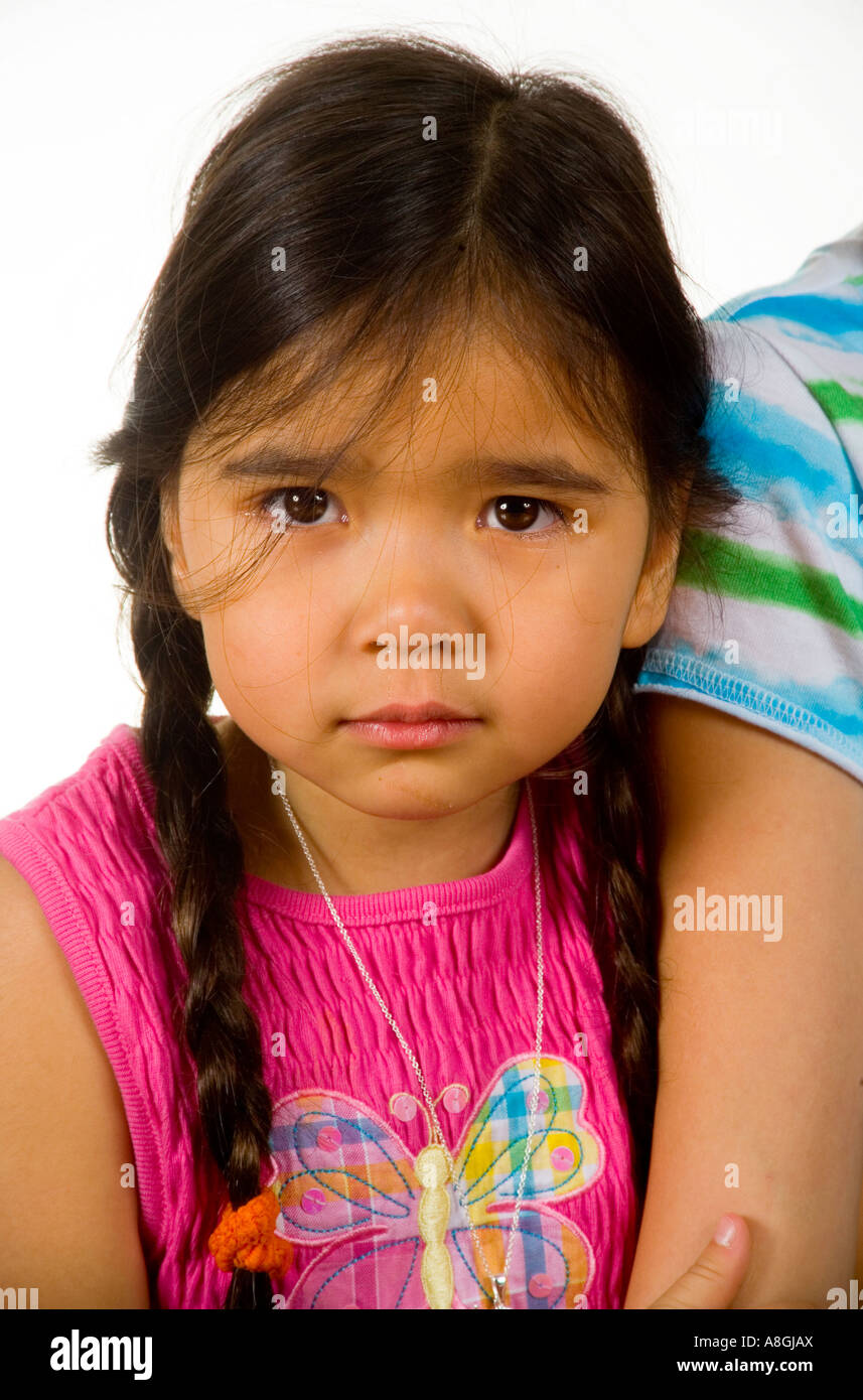 Eine 4 jährige kalifornische chinesische Amerikanerin schmiegt sich an ihre ältere Schwester s Arm Stockfoto