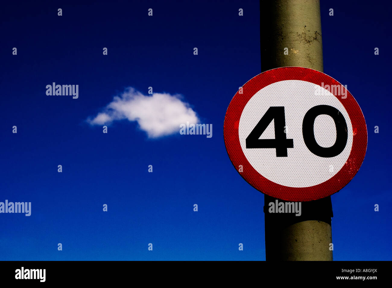 Straßenschild 40 Meilen pro Stunde Höchstgeschwindigkeit gegen den tiefblauen Himmel mit einer einzigen flauschige weiße Wolke im Hintergrund Stockfoto