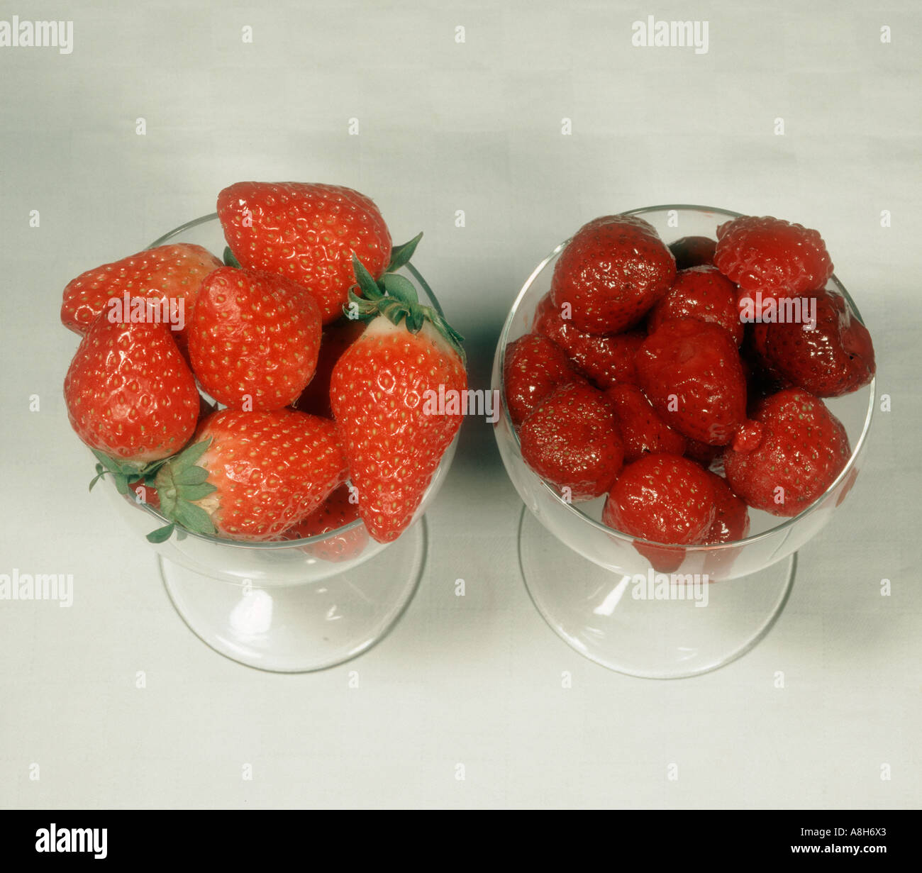 Vergleich von frischen Erdbeeren Früchte und gefrorenes Obst Stockfoto