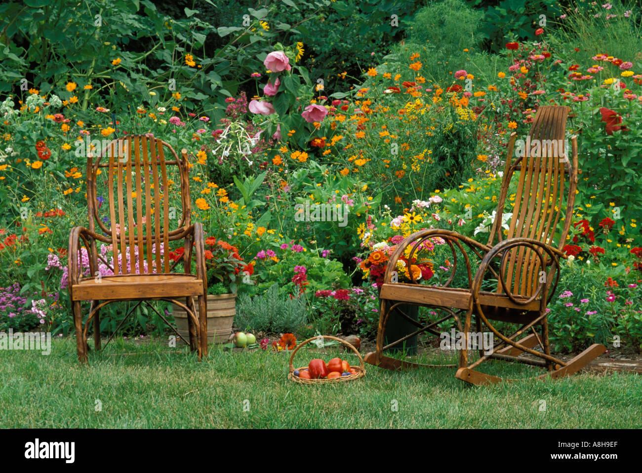 Oma und Opa es bunt Sommergarten: Bugholzstühle in Midwest Blumengarten mit frischem Obst, USA Stockfoto