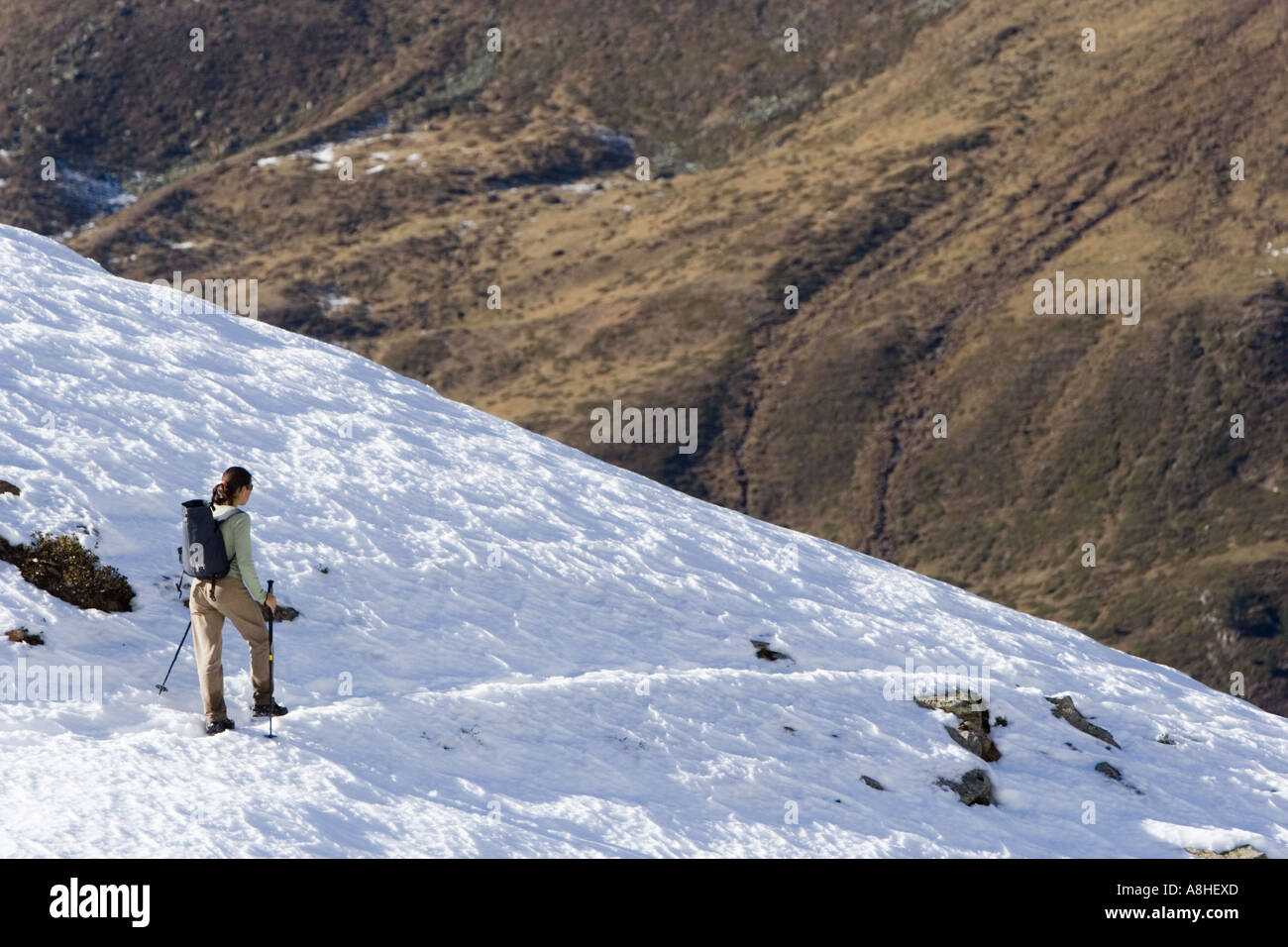 Junge Frau trekking auf der Schneegrenze in den Bergen von Südtirol, Italien Stockfoto