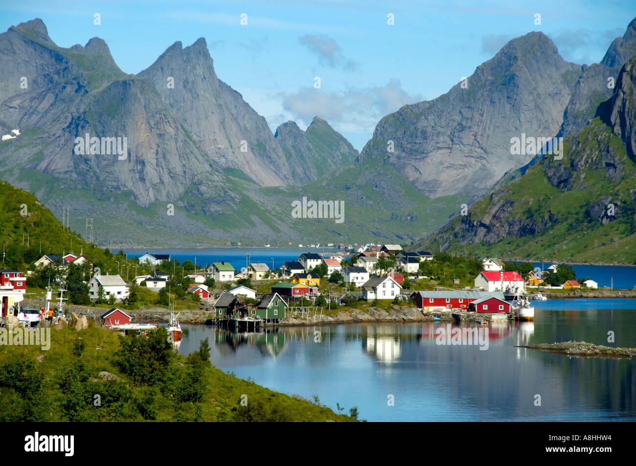 Rauhe Berge und Häuser spiegeln im Fjord Reine Moskenesoya Lofoten Norwegen Stockfoto