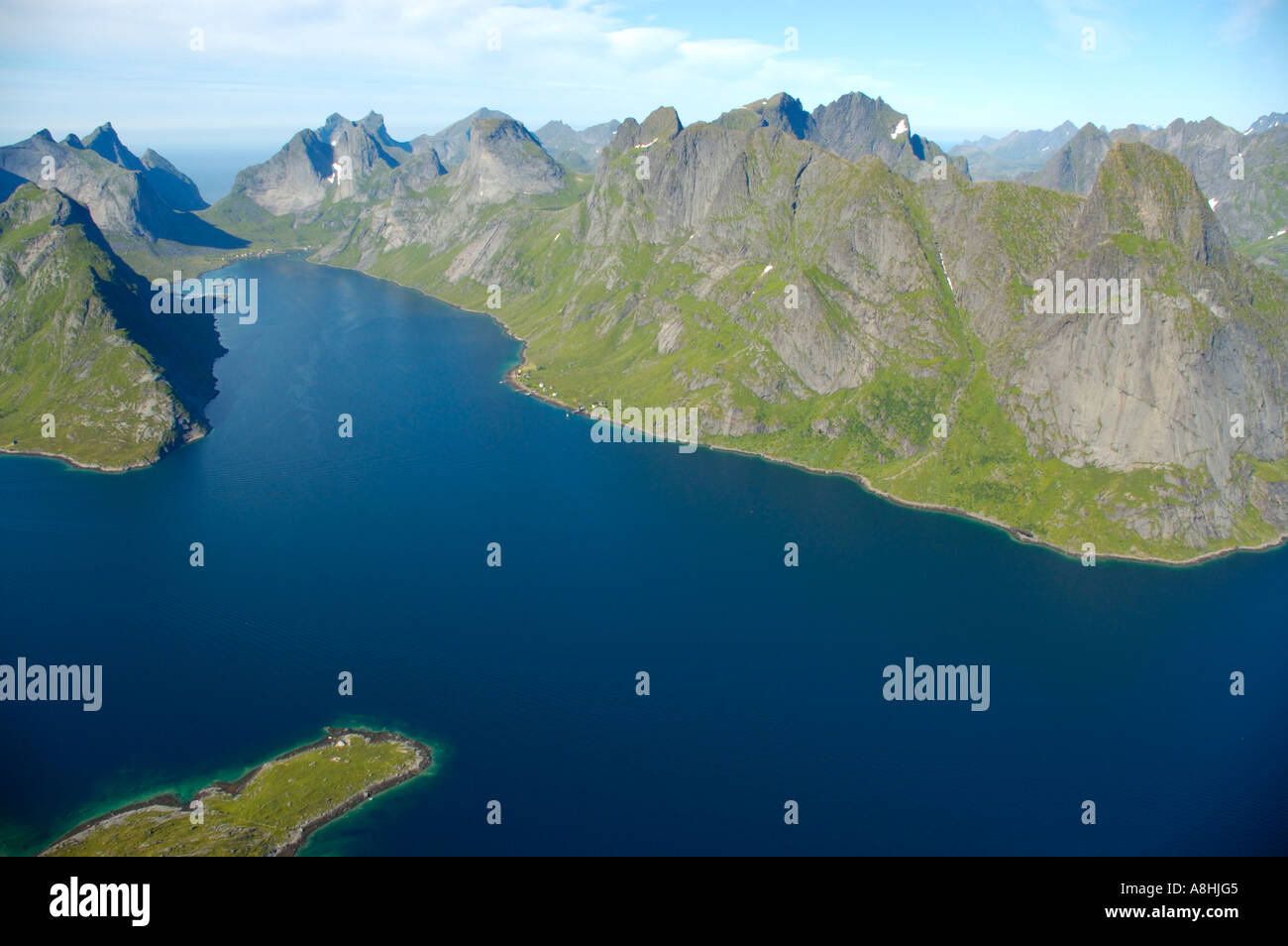 Rauhe Gebirgskette mit Fjord Kjerkfjorden und Boot Moskenesoya Lofoten Norwegen Stockfoto