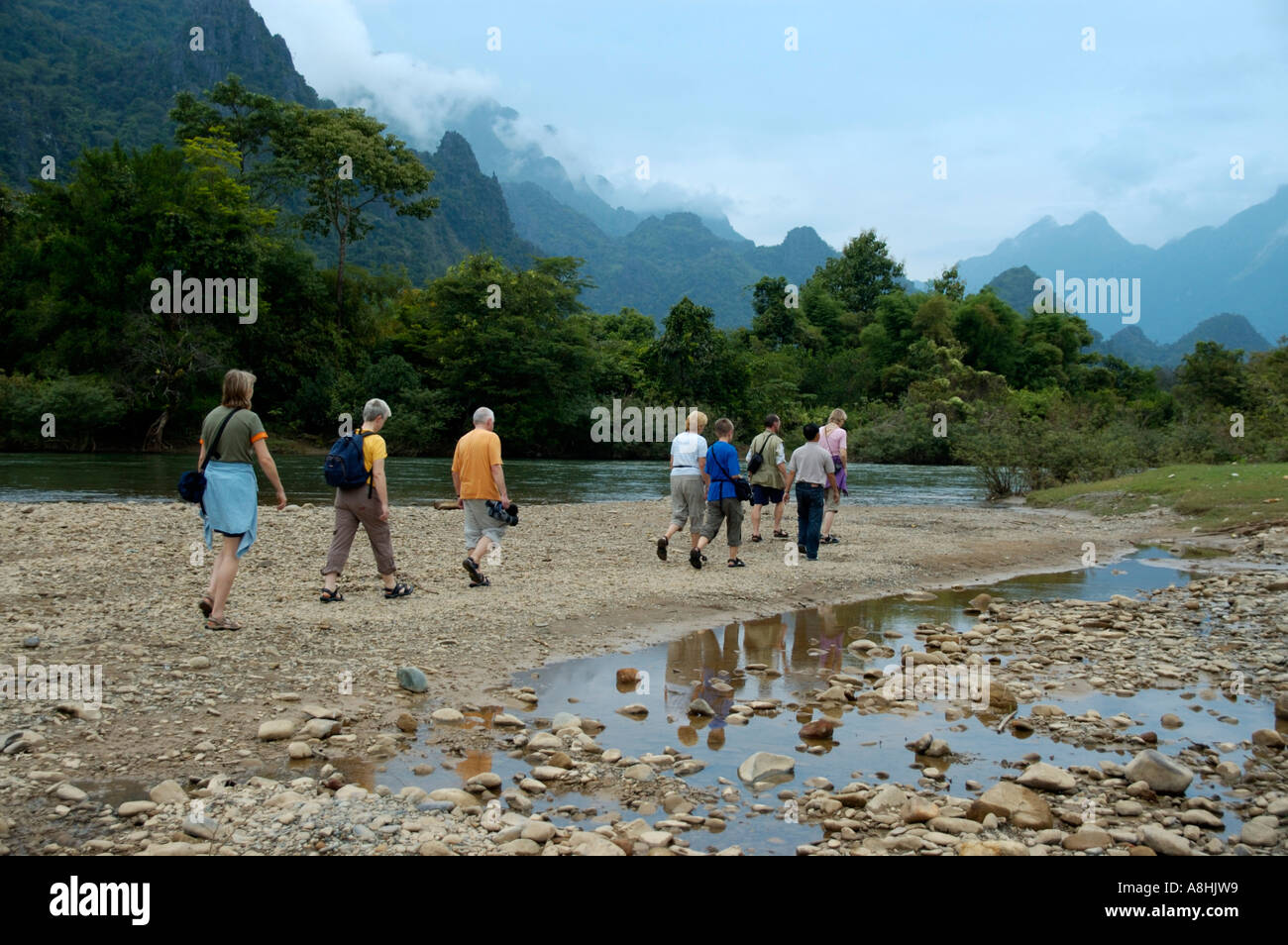 Gruppe von Touristen zu Fuß durch den Fluss in der Nähe von Vang Vieng Laos Stockfoto