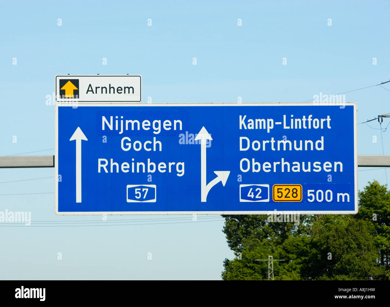 Autobahnschilder auf einer deutschen Autobahn zu Städten in den Niederlanden und Deutschland. Hinweisschild über dem Dach in der Nähe der niederländischen Grenze Stockfoto