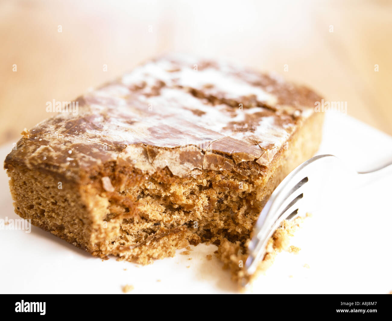 Scheibe Ingwer Kuchen auf Teller mit der Gabel herausgenommen und gegessen, glitzernde glänzende Spitze Stockfoto