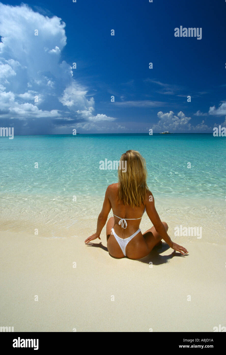 Cayman-Inseln Grand Cayman Frau im Tanga am Strand an der Wasserlinie Stockfoto