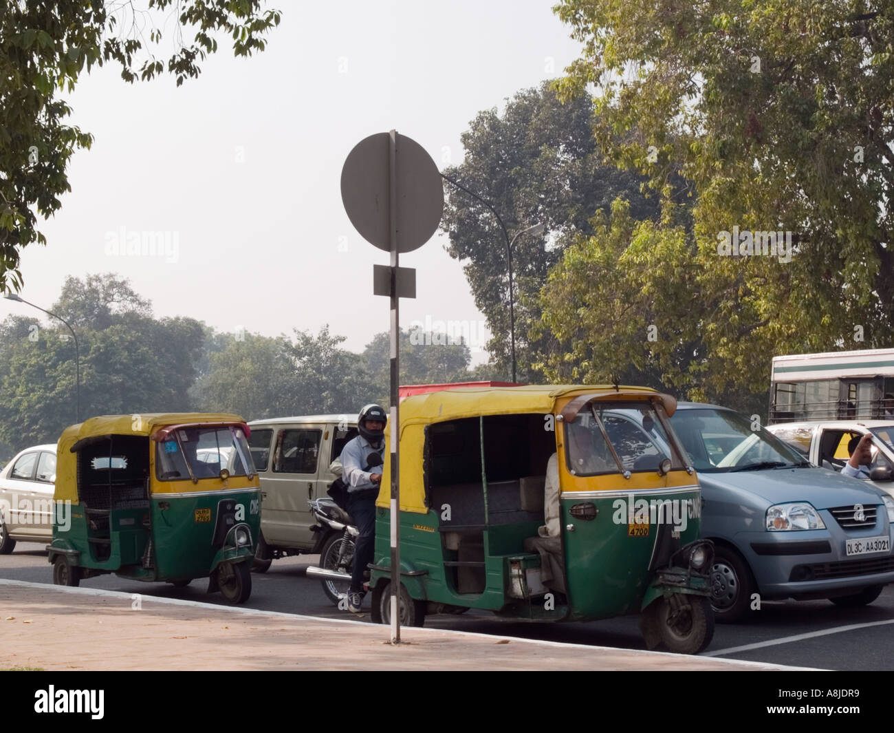 Verkehr auf der viel befahrenen Straße mit grünen und gelben Autorikscha von komprimiertem Erdgas CNG angetrieben. Neu-Delhi Indien Stockfoto