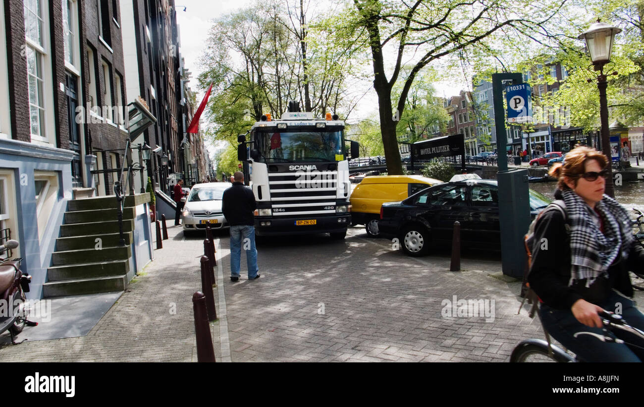 Ein großer Lastwagen versucht, geparkte Autos in Amsterdam zu überholen Stockfoto